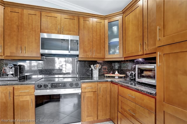 kitchen featuring dark stone counters, tasteful backsplash, and stainless steel appliances