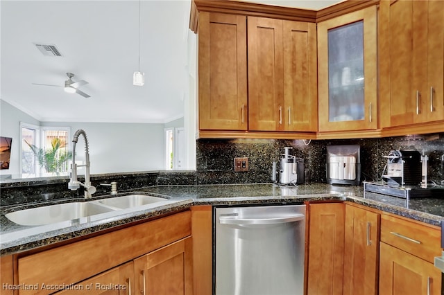 kitchen featuring dark stone counters, crown molding, sink, stainless steel dishwasher, and ceiling fan