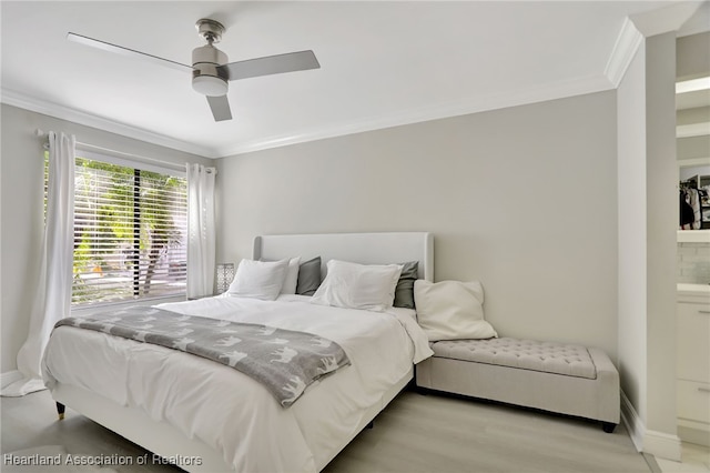 bedroom featuring ceiling fan, light hardwood / wood-style flooring, crown molding, and ensuite bath