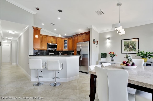 kitchen with pendant lighting, a breakfast bar, lofted ceiling, sink, and stainless steel appliances