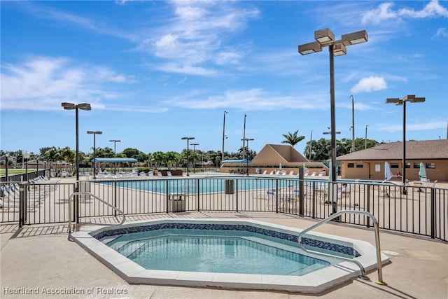 view of swimming pool with a hot tub