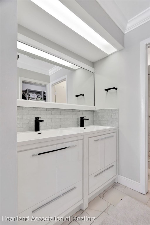 bathroom featuring vanity, crown molding, and backsplash