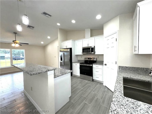 kitchen featuring light stone counters, stainless steel appliances, ceiling fan, decorative light fixtures, and white cabinets