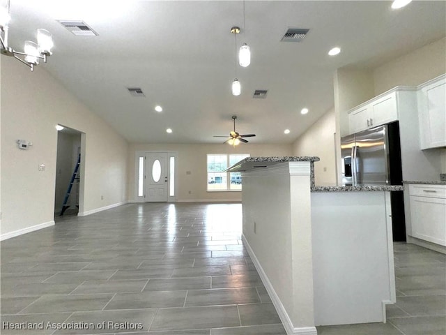 kitchen with stainless steel fridge, white cabinetry, ceiling fan, and hanging light fixtures