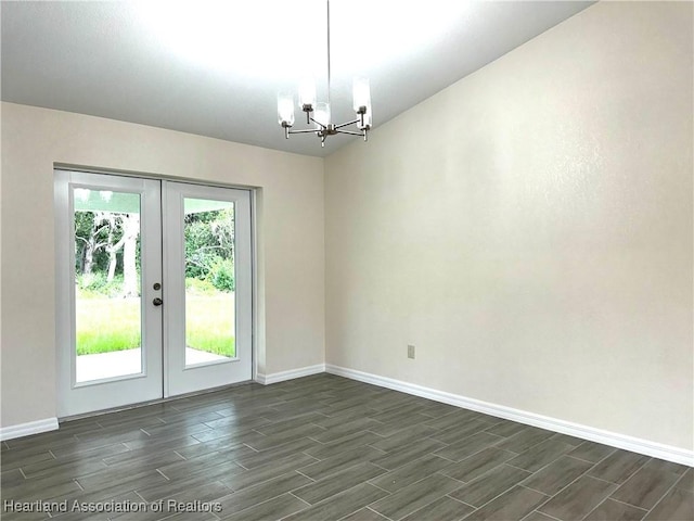 spare room featuring a chandelier and french doors