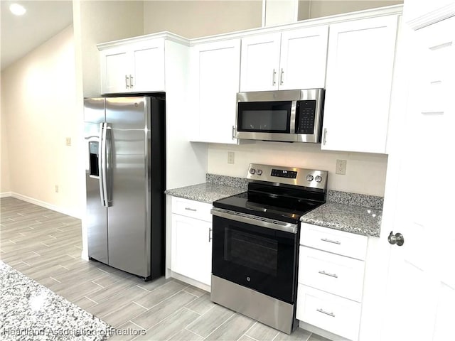 kitchen featuring light stone countertops, white cabinetry, and stainless steel appliances