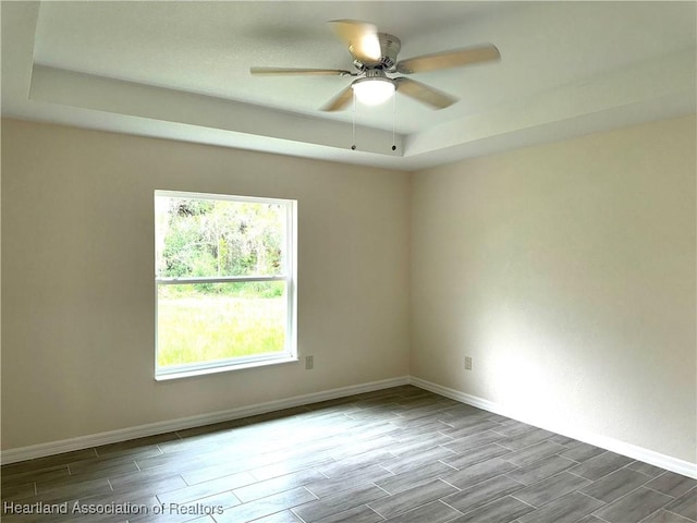 empty room with a tray ceiling and ceiling fan