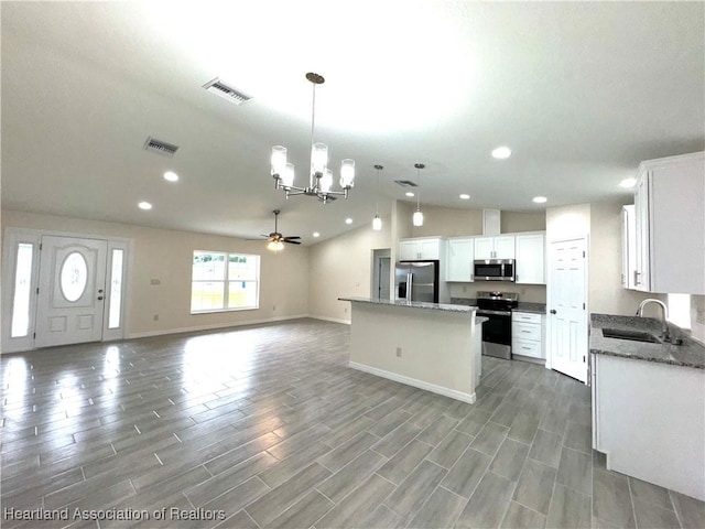 kitchen featuring white cabinetry, a center island, sink, stainless steel appliances, and decorative light fixtures