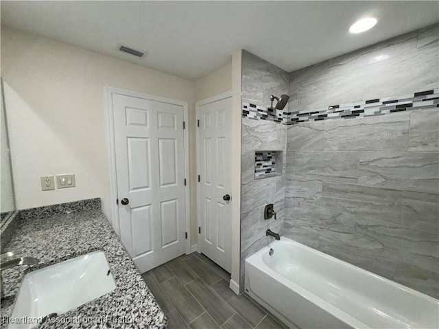 bathroom with vanity and tiled shower / bath