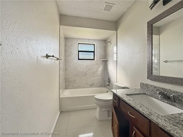 full bathroom with tile patterned floors, vanity, a textured ceiling, toilet, and tiled shower / bath