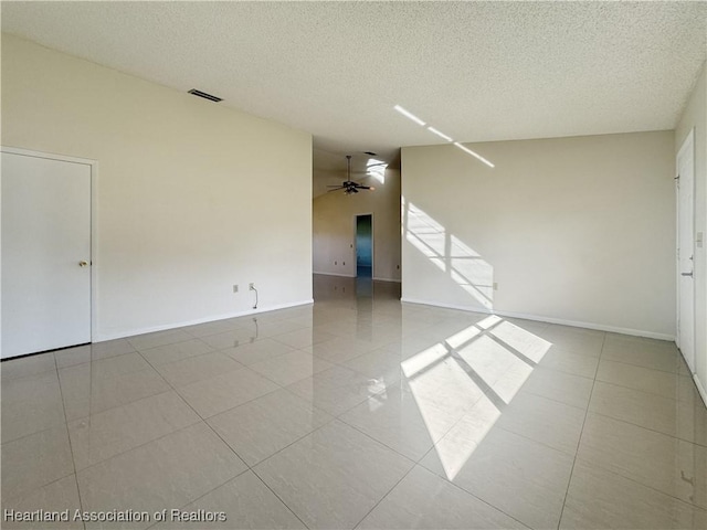 unfurnished room with ceiling fan and a textured ceiling