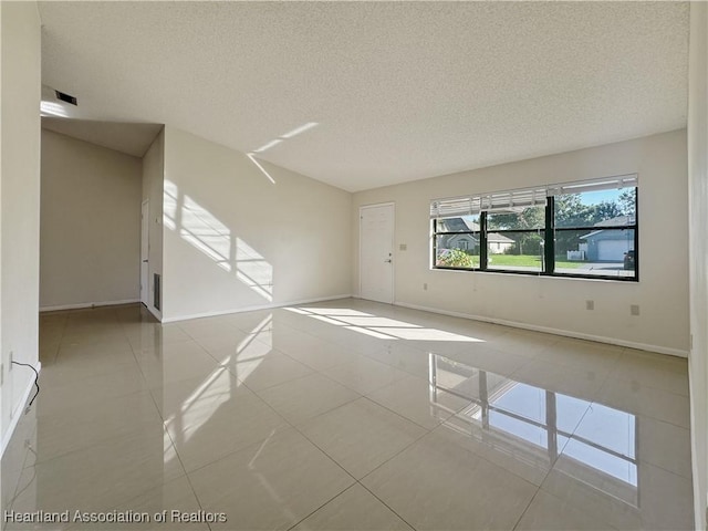 spare room with light tile patterned floors and a textured ceiling