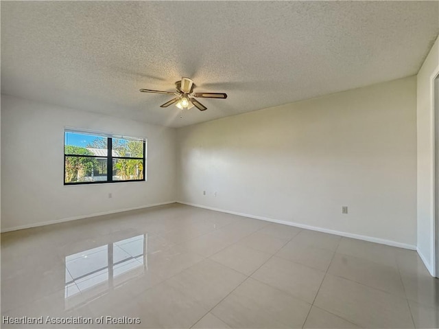 unfurnished room with ceiling fan, light tile patterned floors, and a textured ceiling