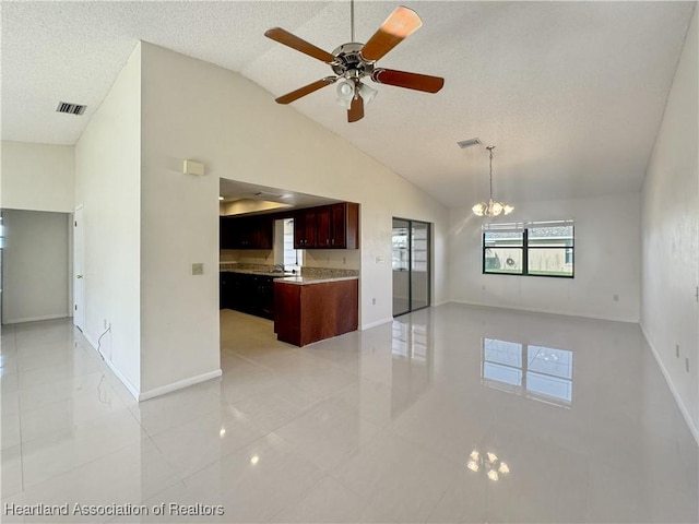 unfurnished living room with ceiling fan with notable chandelier, sink, vaulted ceiling, light tile patterned floors, and a textured ceiling