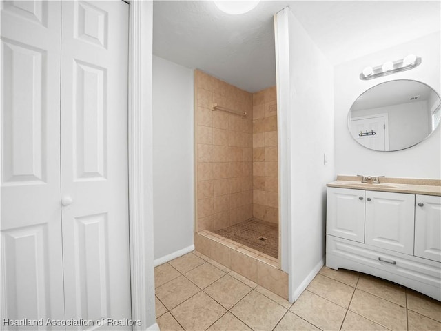 bathroom featuring baseboards, tile patterned flooring, and tiled shower