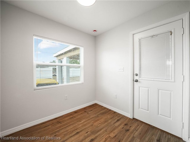 empty room with baseboards and wood finished floors