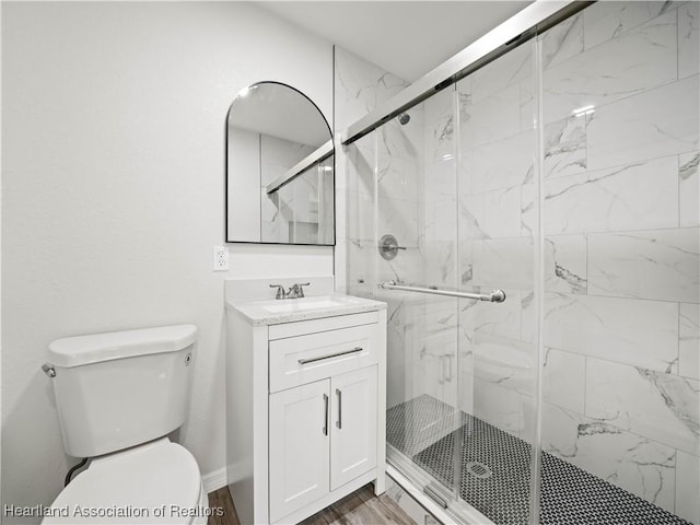 full bathroom with a marble finish shower, vanity, and toilet