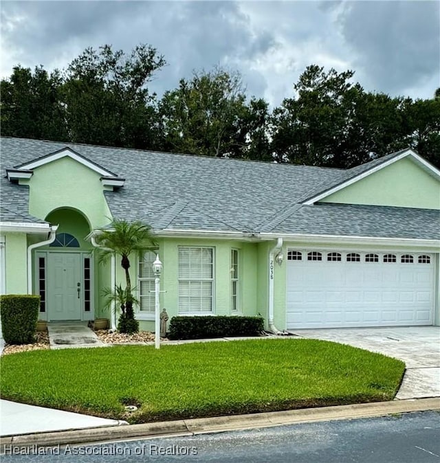 ranch-style home with a garage and a front lawn