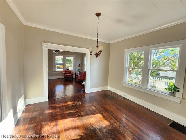 empty room featuring visible vents, hardwood / wood-style floors, crown molding, baseboards, and a chandelier