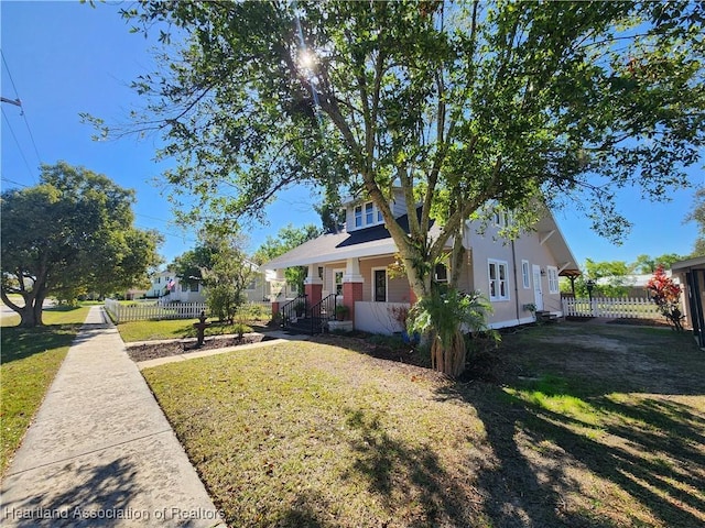 view of property exterior with a lawn and fence