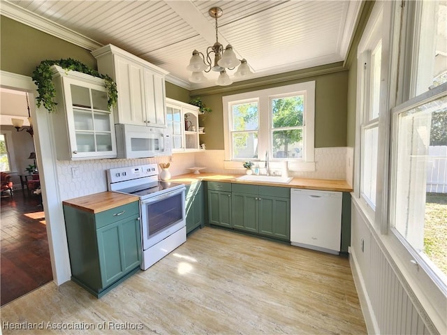 kitchen with light wood-type flooring, ornamental molding, a sink, wood counters, and white appliances