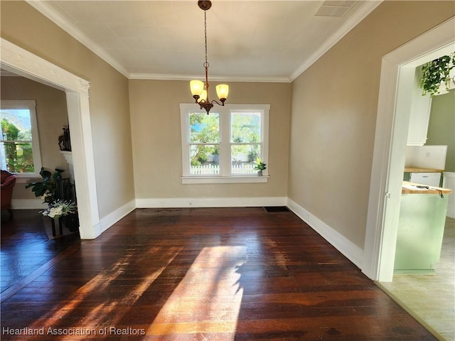 unfurnished room featuring visible vents, baseboards, ornamental molding, wood-type flooring, and a chandelier