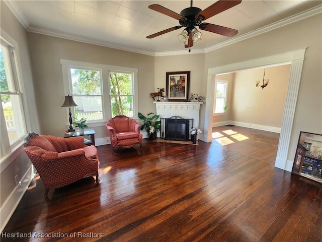 living area with a fireplace with flush hearth, a healthy amount of sunlight, crown molding, and wood-type flooring