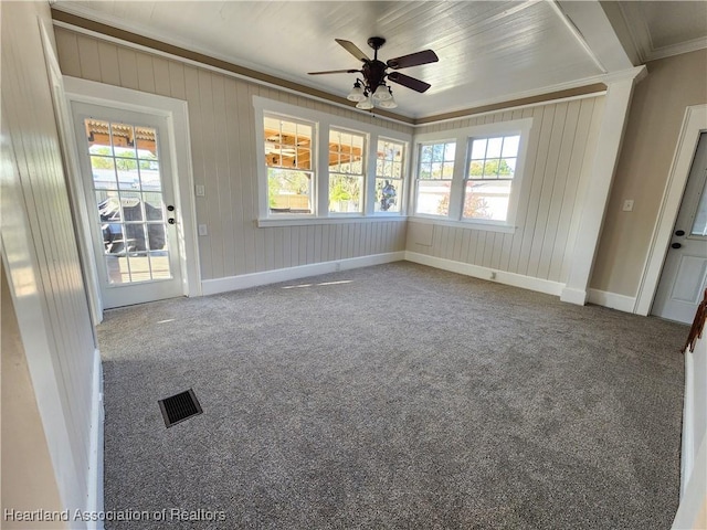 carpeted spare room with visible vents, plenty of natural light, crown molding, and baseboards