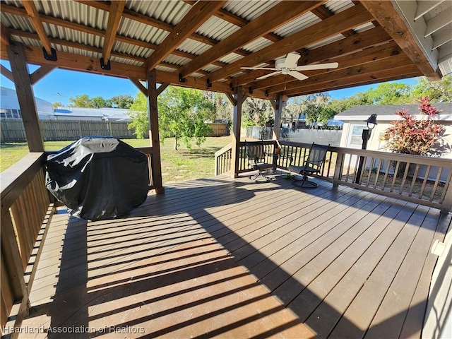 deck with a yard, a ceiling fan, a fenced backyard, and grilling area