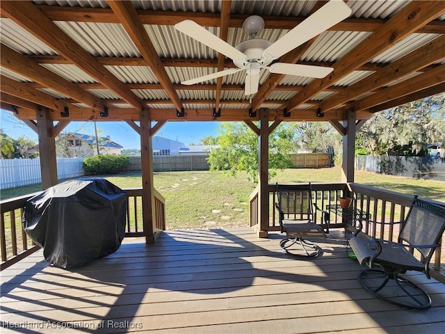 wooden terrace with grilling area, a yard, and a fenced backyard