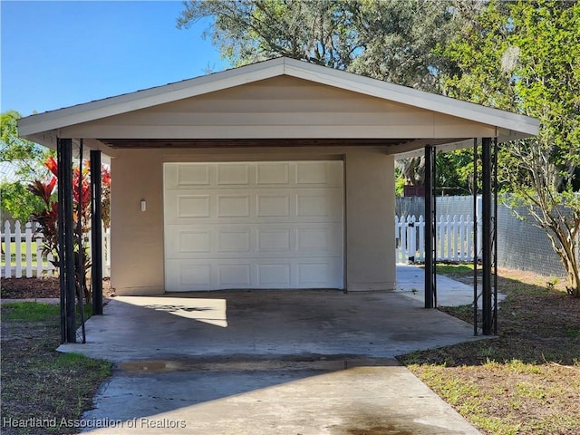 garage with fence and driveway