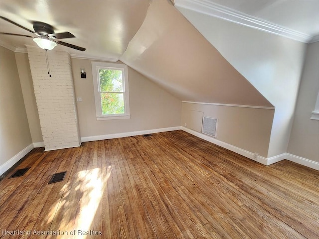 additional living space with visible vents, lofted ceiling, baseboards, and hardwood / wood-style flooring