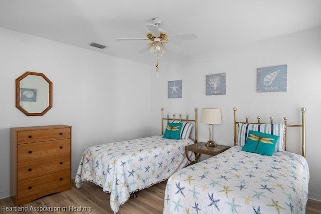 bedroom with visible vents, wood finished floors, and ceiling fan