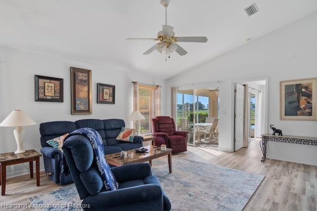 living area with visible vents, a ceiling fan, light wood-style flooring, and vaulted ceiling