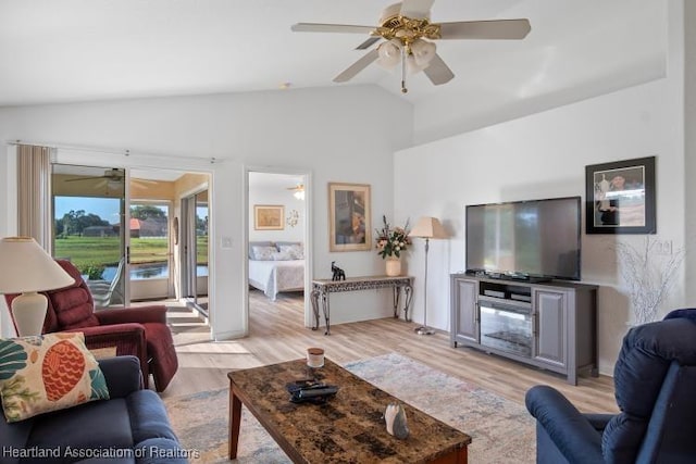living area featuring light wood-type flooring, a ceiling fan, and high vaulted ceiling