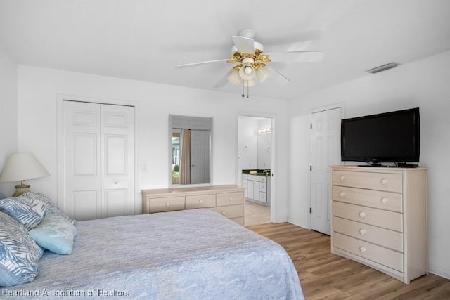 bedroom with a closet, a ceiling fan, visible vents, light wood-style flooring, and ensuite bathroom