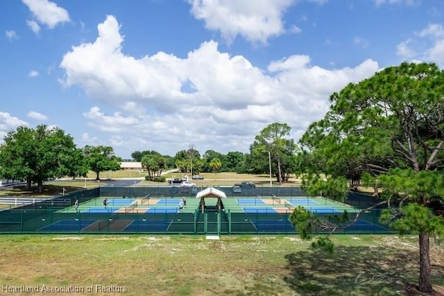 view of basketball court featuring a tennis court and fence