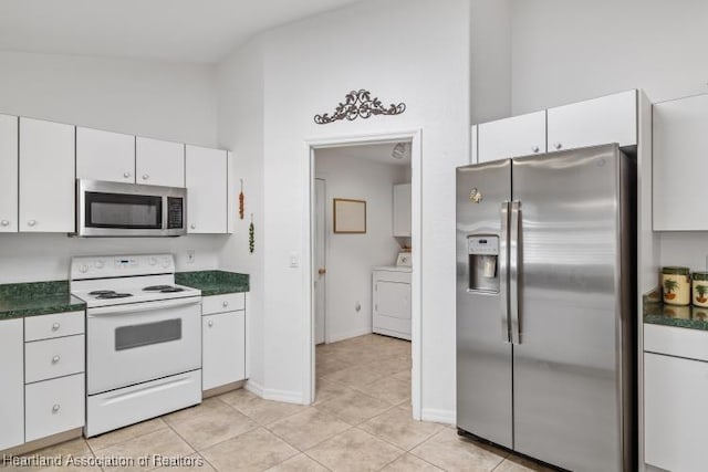kitchen with stainless steel appliances, light tile patterned floors, washer / dryer, white cabinetry, and dark countertops