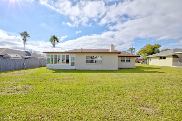 back of house featuring a sunroom and a yard