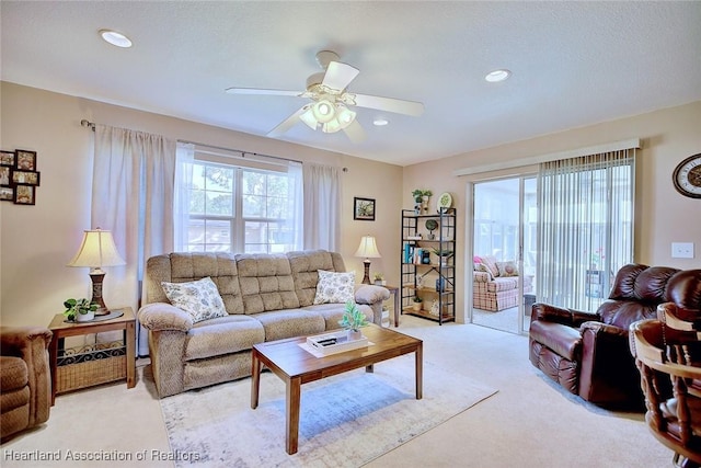 carpeted living room with ceiling fan