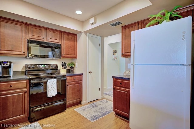 kitchen featuring light wood-type flooring and black appliances