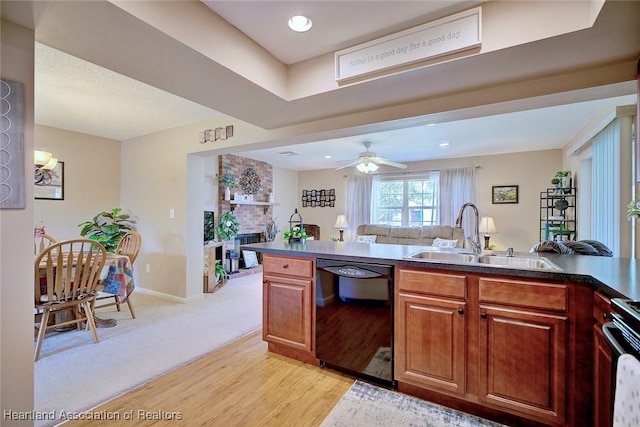 kitchen featuring stove, a fireplace, ceiling fan, sink, and dishwasher