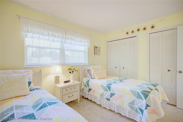 carpeted bedroom featuring multiple closets