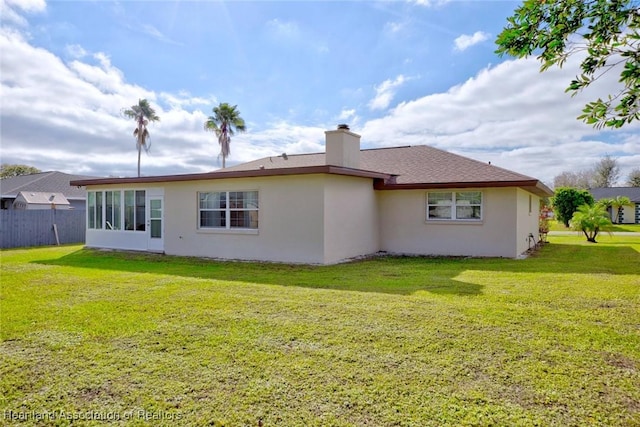 rear view of property featuring a lawn