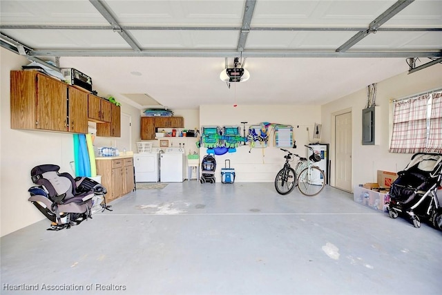 garage with electric panel, a garage door opener, and washer and clothes dryer