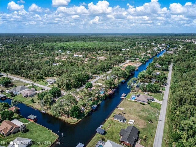 aerial view featuring a view of trees, a residential view, and a water view