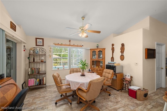 dining space featuring a ceiling fan, baseboards, and vaulted ceiling
