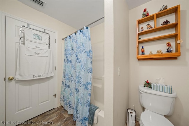 bathroom with stone finish floor, visible vents, toilet, and shower / bath combo with shower curtain