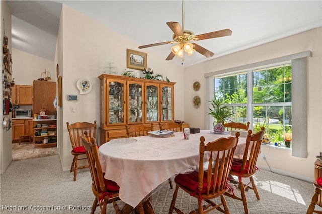 dining area with baseboards, ceiling fan, a toaster, and light carpet