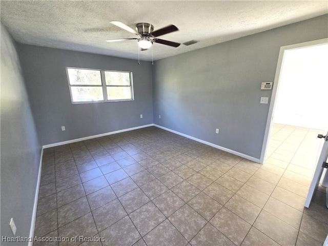 tiled spare room with ceiling fan and a textured ceiling